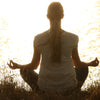 woman meditating by water
